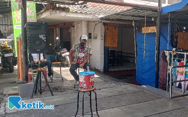 Thumbnail Pengamen menghibur pengunjung di depan Plaza Batu Kota Batu Jawa Timur. (Foto: Sholeh/ketik.co.id)