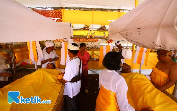 Thumbnail Umat Hindu mengikuti ritual Metatah atau potong gigi massal di Krematorium Setra Ganda Wangi, Kelurahan Talang Jambe, Kecamatan Sukarami Palembang, Sumatera Selatan, Jumat (7/6/2024). Prosesi potong gigi massal yang diikuti sebanyak 14 orang umat Hindu sebagai simbol untuk membersihkan keangkaramurkaan dan keserakahan dari diri seseorang. Ada 6 buah gigi yang dikikis sebagai simbol sad ripu, yaitu 4 buah gigi seri dan 2 buah gigi taring. (Wahyu Rahmanto/Ketik.co.id)