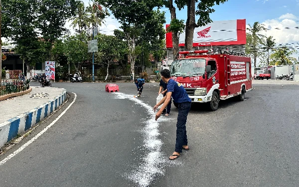 Thumbnail Berita - Bikin Warga Terpeleset, Damkar Bondowoso Taburi Semen Putih di Jalanan yang Ada Ceceran Solar