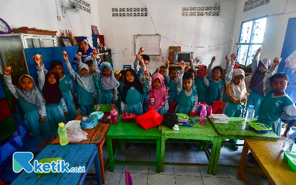 Thumbnail Murid-murid mengangkat sebutir telur rebus yang dipegang masing-masing saat snack time di TK Bustanul Athfal Wirosari, Kabupaten Grobogan, Jawa Tengah, Sabtu, 14 September 2024. Snack time yang diprogramkan oleh pihak sekolah ini merupakan salah satu upaya pemenuhan asupan gizi bagi murid dan pencegahan stunting sejak dini. (Foto: Achmad Fazeri/Ketik.co.id)