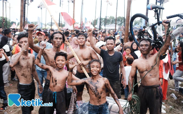 Thumbnail Foto bersama salah satu tim pemanjat pinang yang telah berhasil menurunkan seluruh hadiah. (Foto: Wisnu Akbar Prabowo/Ketik.co.id)